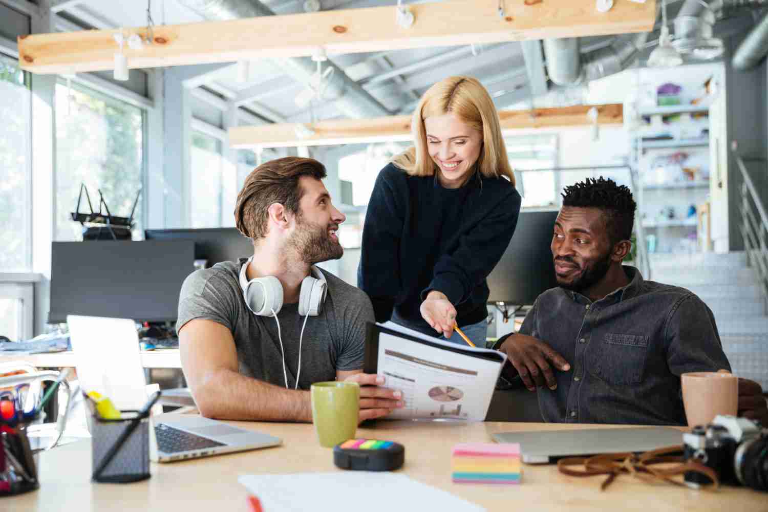 Three professionals engaged in a discussion at a modern workspace, collaborating on a branding strategy. Bold Brand Refresh.