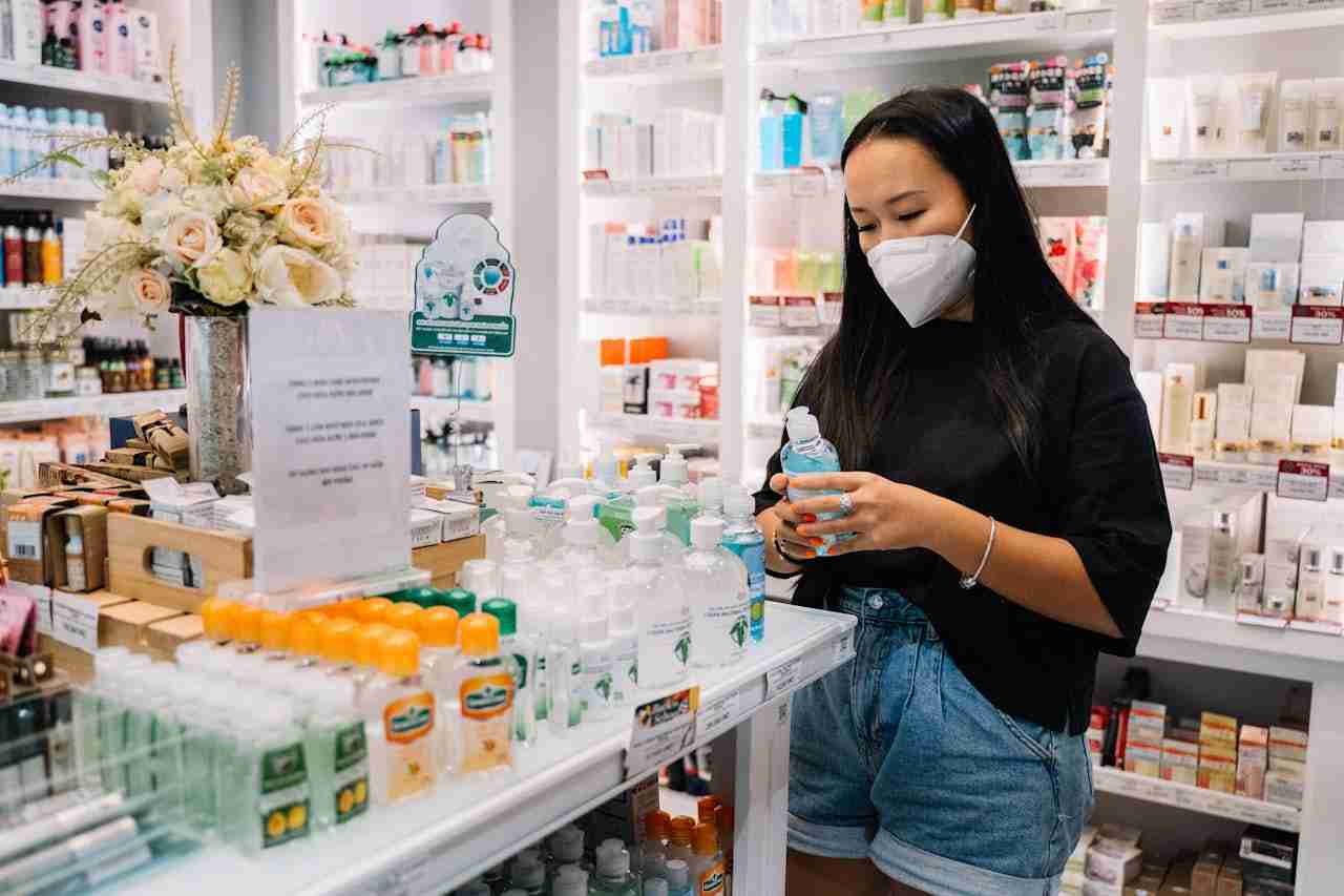 Pharmacy owner using a tablet to manage online orders and review local marketing performance on Google and WhatsApp, guided by a digital agency.